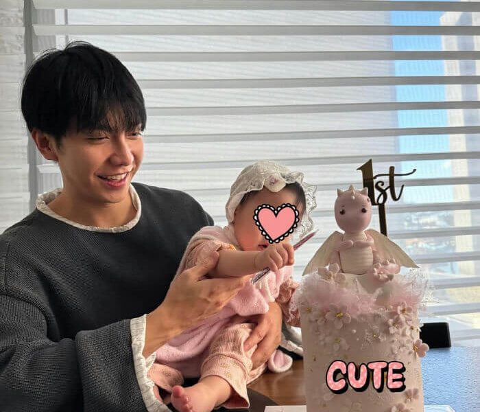 people-A-man smiling-A-baby being held-B-first birthday celebration-C-dragon cake