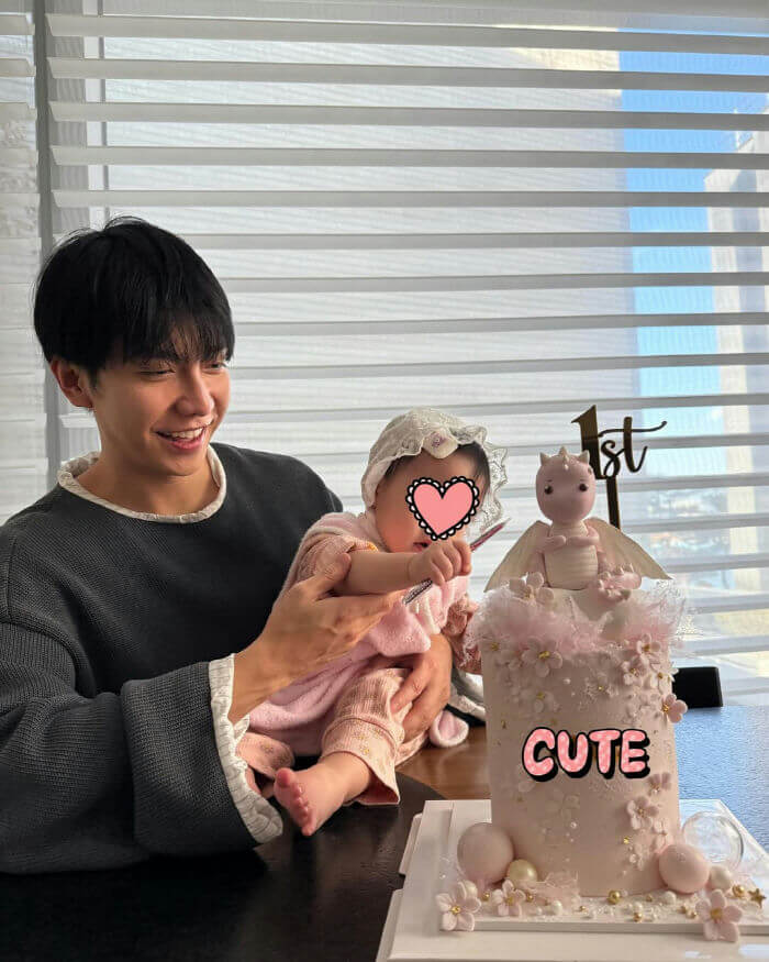 people-A-man smiling-A-baby being held-B-first birthday celebration-C-dragon cake
