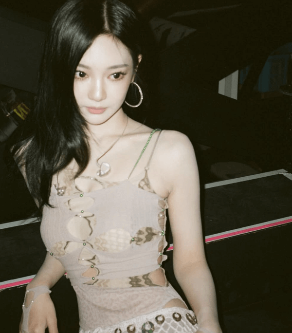 people-woman-A-long black hair-A-tan cutout top-A-hoop earrings-A-pale skin