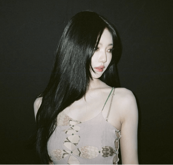 people-woman-A-long black hair-A-light skin tone-A-light brown spaghetti strap top-A-dark background