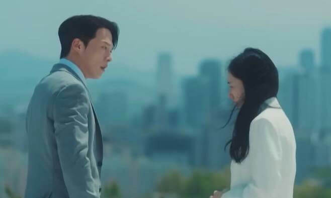 people-man in light blue suit-A-woman in white jacket-B-outdoor setting with blurry city skyline-C