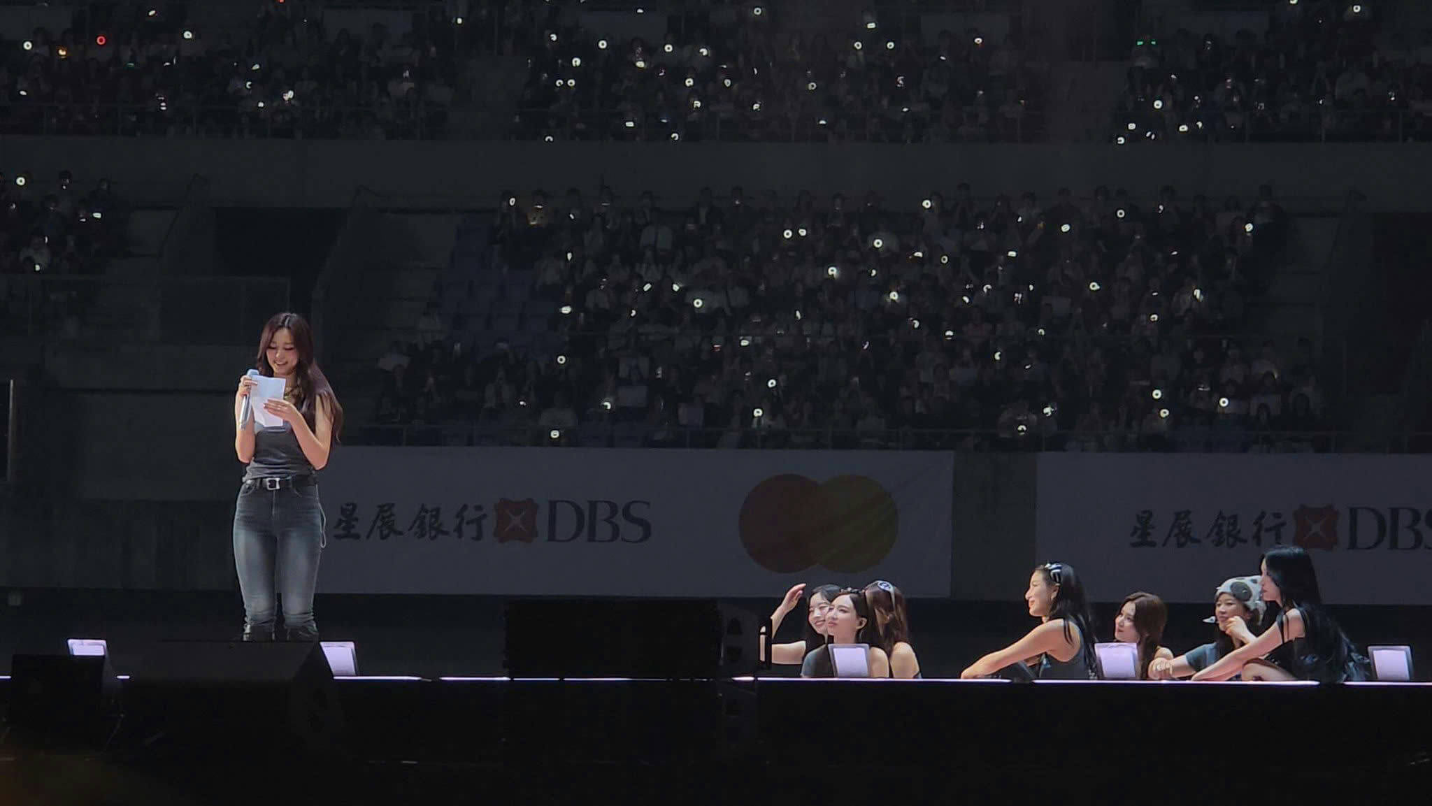people-A-singer on stage-A-holding script-B-audience with lights-C-sponsors banner