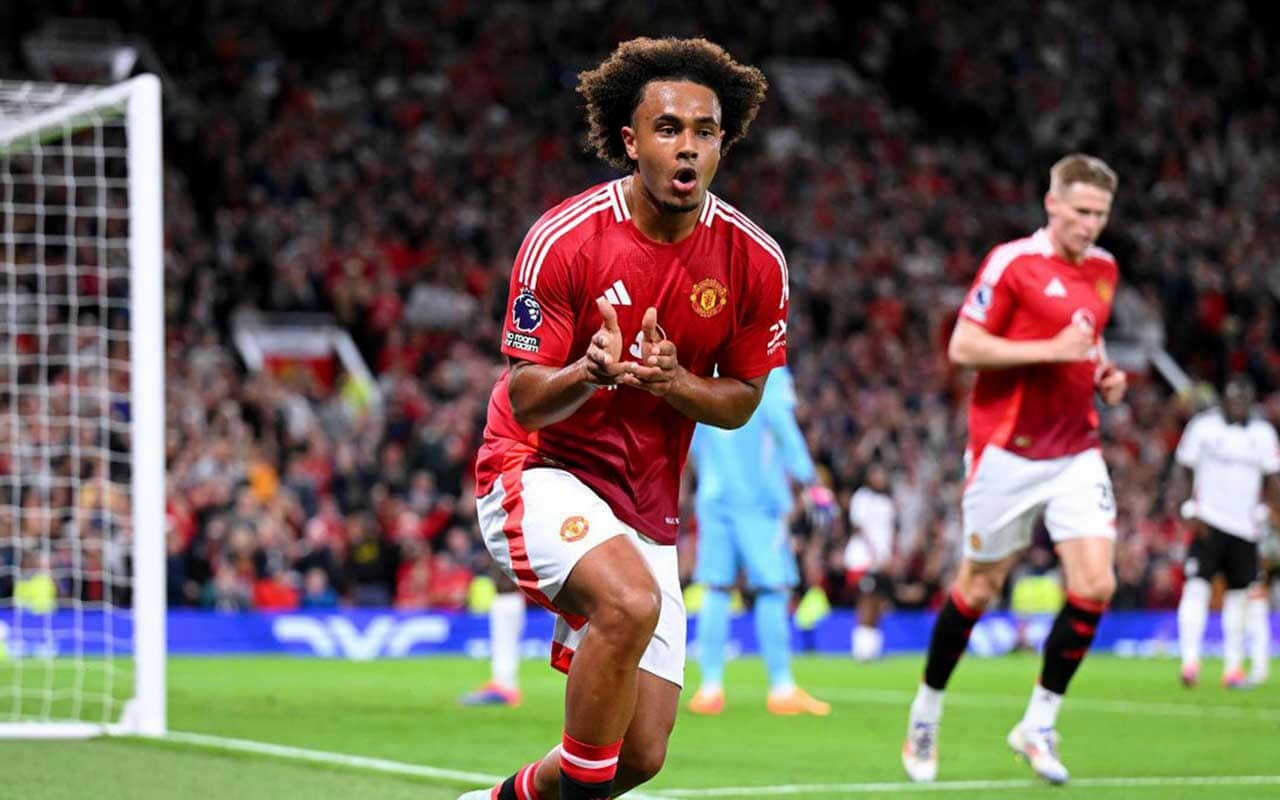 people-Football player in red jersey celebrating-A-Manchester United kit-B-Crowd in background-C-Soccer goalpost