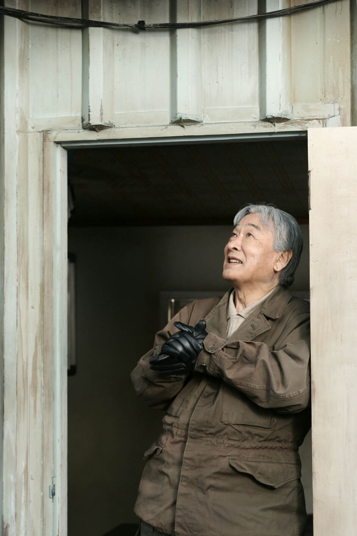 people-Asian man-A-older man-A-looking up-B-wearing gloves-B-standing in doorway-C