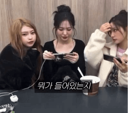 people-three young women-A-playing mobile games-A-holding phones-A-Korean subtitles (meaning 