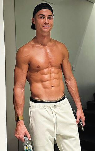 people-Cristiano Ronaldo-shirtless-muscular physique-abs-black baseball cap-white sweatpants