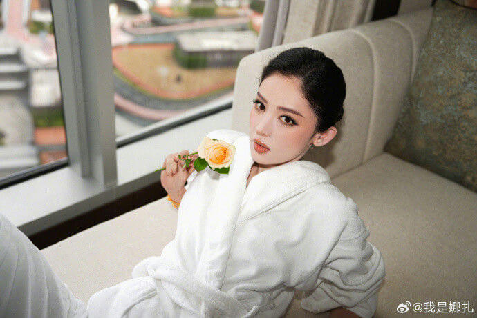people-1-woman-A-white bathrobe-B-holding a peach rose-C-sitting by a window