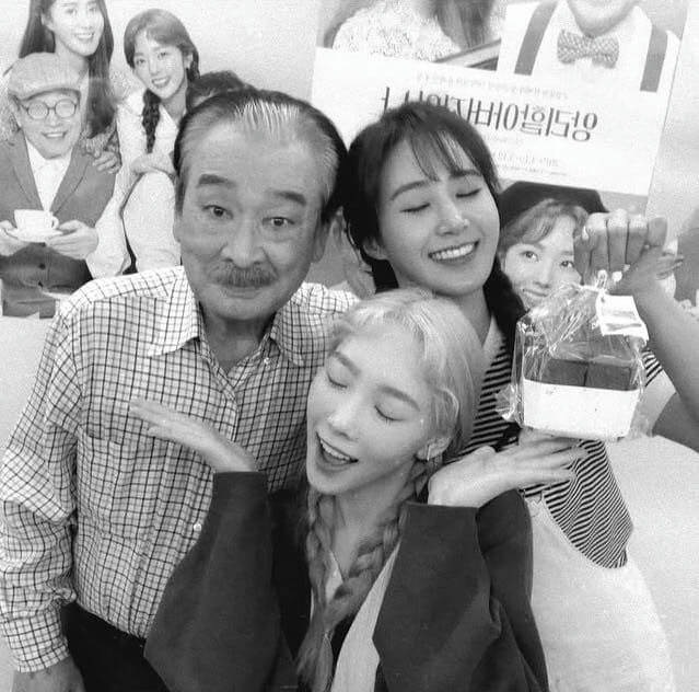 people-Three people in foreground-A-Man with mustache-A-Woman with light hair and braids-A-Woman with dark hair smiling