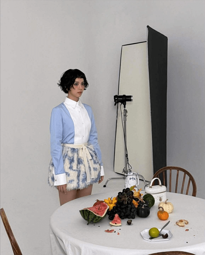 people-A-woman-A-short black hair-B-light blue and white shirt-C-fluffy patterned skirt