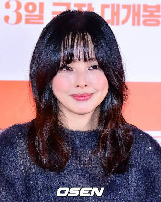 people-Korean woman-dark hair-fringed bangs-pink blush-chunky knit sweater-smiling