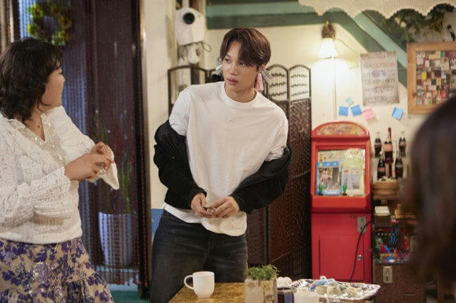 people-man in white t-shirt and black jacket-A-woman in white lacy top-B-casual indoor setting-C-red arcade machine