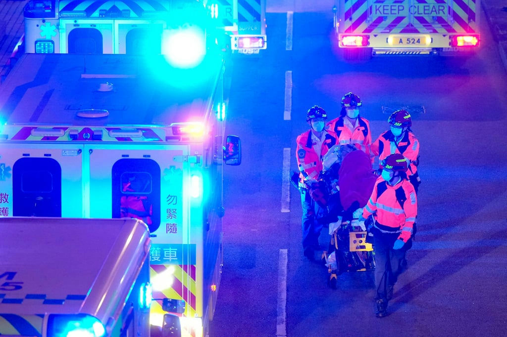 people-Four-paramedics-A-carrying-A-patient-A-on-A-stretcher-B-ambulances-B-flashing-blue-and-red-lights-C-nighttime-scene-C-street