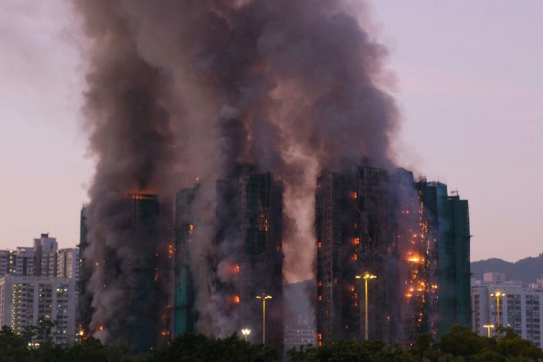 people-A-large fire-A-tall buildings-A-heavy smoke-A-construction scaffolding-B-dusk sky-C