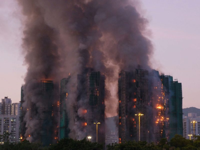 people-A-large fire-A-tall buildings-A-heavy smoke-A-construction scaffolding-B-dusk sky-C