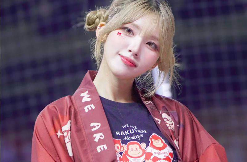 people-One woman-A-blonde hair in buns-B-red and white jacket with Japanese style sleeves-C-dark t-shirt with