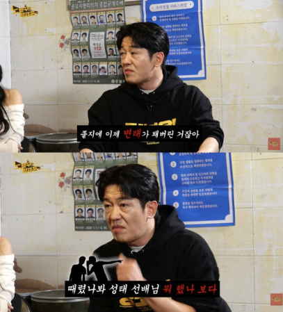 people-man in black hoodie-talking-Korean text-wall posters-blue informational sign