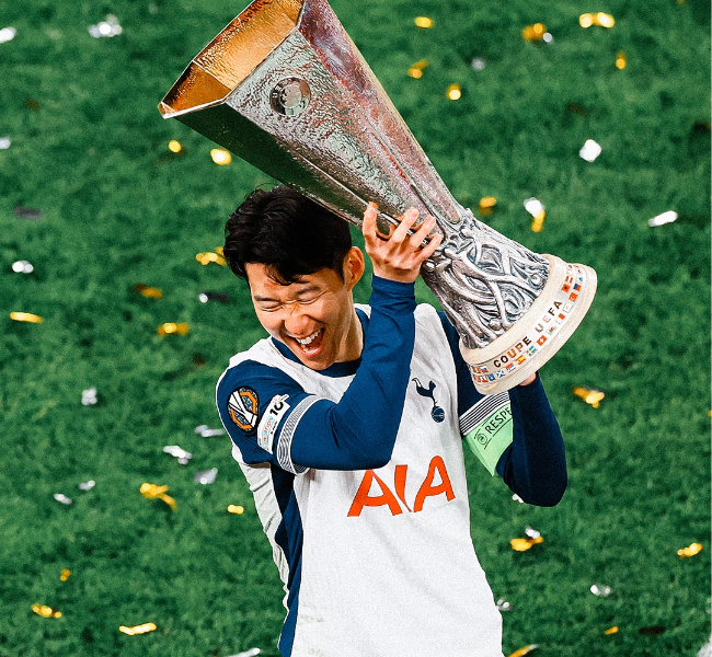 people-Son Heung-min-A-celebrating-A-holding trophy-A-Tottenham Hotspur jersey-B-confetti-C-green grass