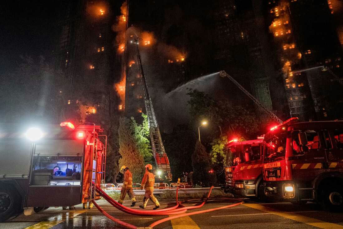 Nighttime fire-A-high-rise-A-firefighters-A-fire-trucks-A-ladder-truck-A-hoses