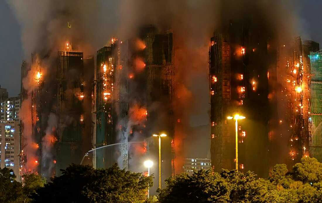 fire-A-skyscraper-A-night-A-smoke-A-flames-A-firefighting-A-streetlights-A-trees-A-construction-scaffolding-A-cityscape