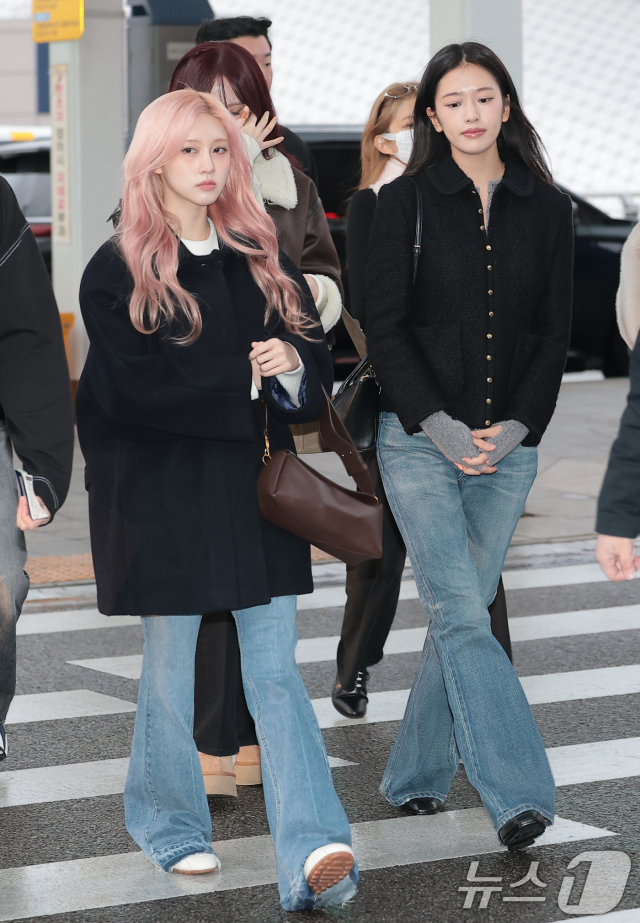 people-2-women-A-pink hair-A-dark coat-B-black jacket-B-flare jeans-C-airport fashion