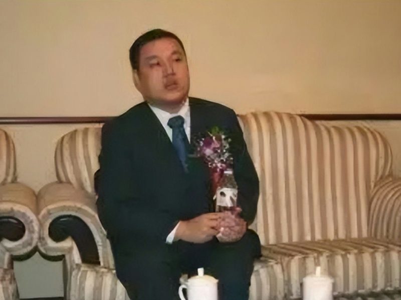 people-1-man-A-suit-B-holding bottle-C-sitting on striped couch