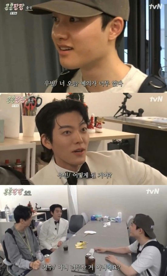 people-D.O. (Do Kyungsoo)-A-wearing a baseball cap-A-talking-B-Kim Woo Bin-A-wearing a white tuxedo jacket-A-surprised expression-B-two other men sitting at a table-A-casual setting-A-tvN logo visible