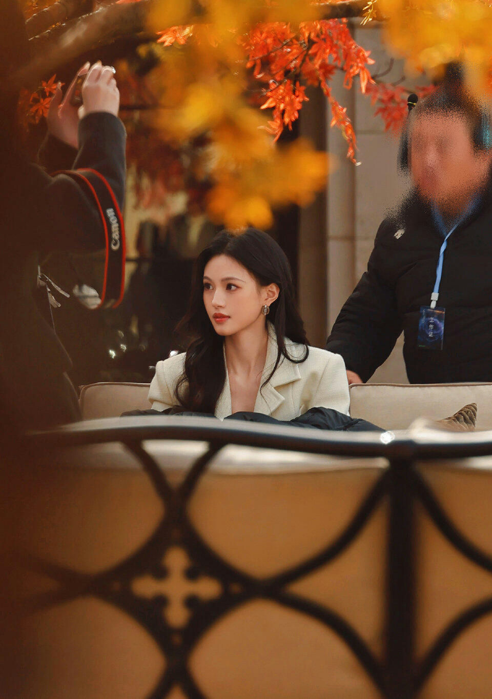 people-woman-young female celebrity-A-outdoor setting-A-photographer taking picture-A-autumn leaves-A-crew member