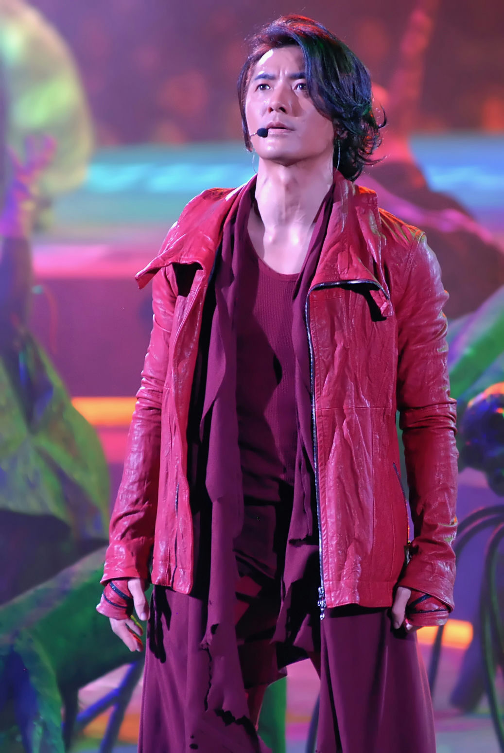 people-Man-A-singer-A-red leather jacket-B-dark red outfit-C-stage performance-D-long dark hair