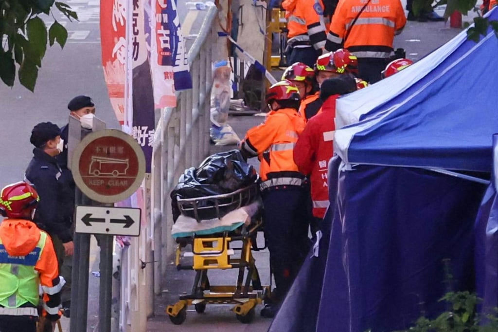 people-emergency responders in orange and red uniforms-A-stretcher covered with a black bag-B-blue tent structure-C-traffic signs including one that says 