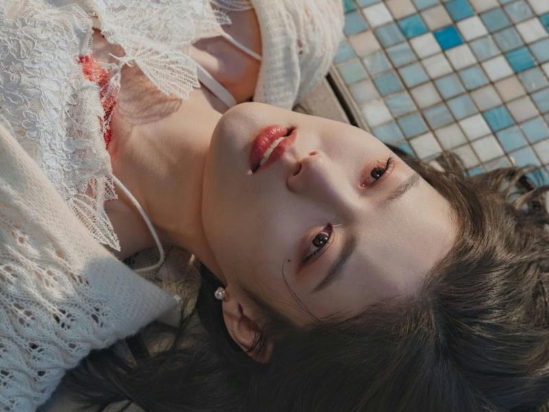 people-woman-lying down-A-white lace and knitwear-B-blue and white mosaic tiles-C-dark hair