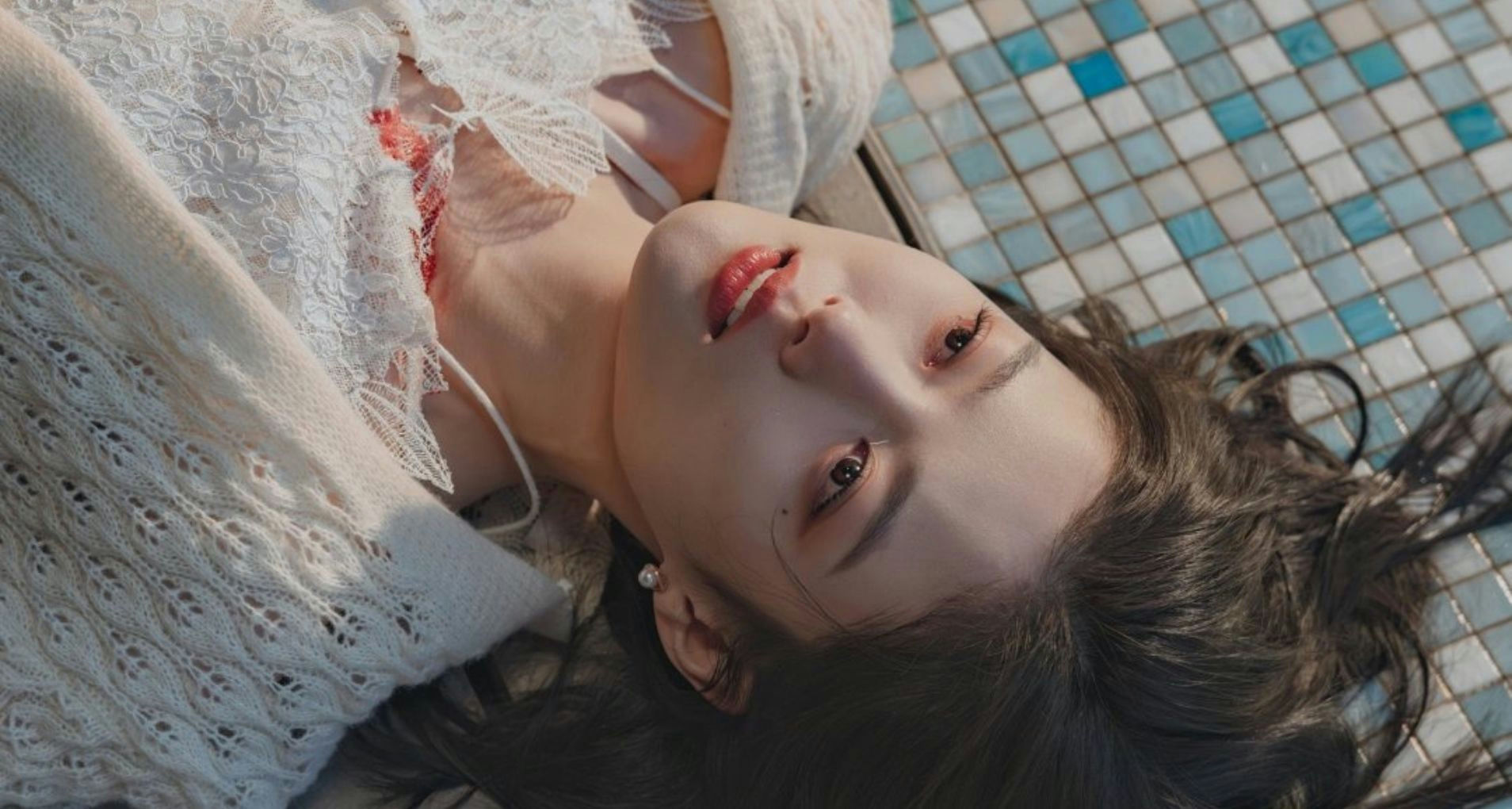 people-woman-lying down-A-white lace and knitwear-B-blue and white mosaic tiles-C-dark hair