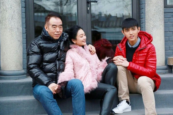 people-man in black puffer jacket-woman in pink fur jacket-young man in red puffer jacket