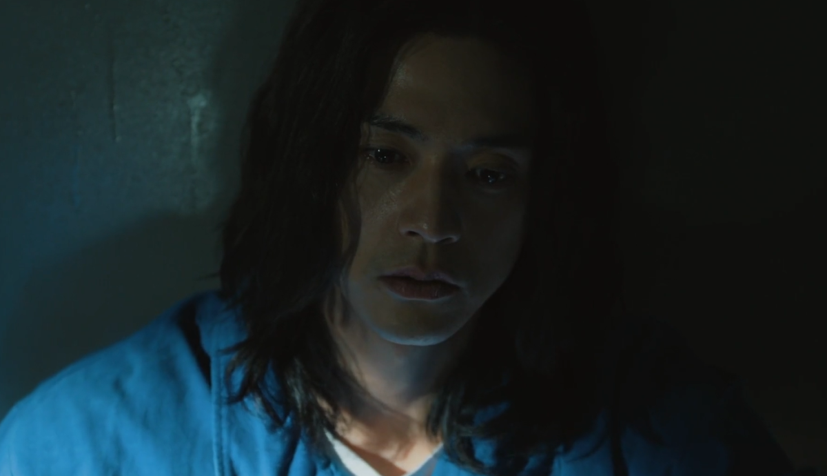 people-male-A-long dark hair-A-pensive expression-B-low light-C-blue shirt