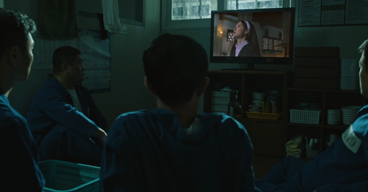people-four men-A-watching TV-A-prison setting-A-dark room-A-Korean-B-nun on screen-C