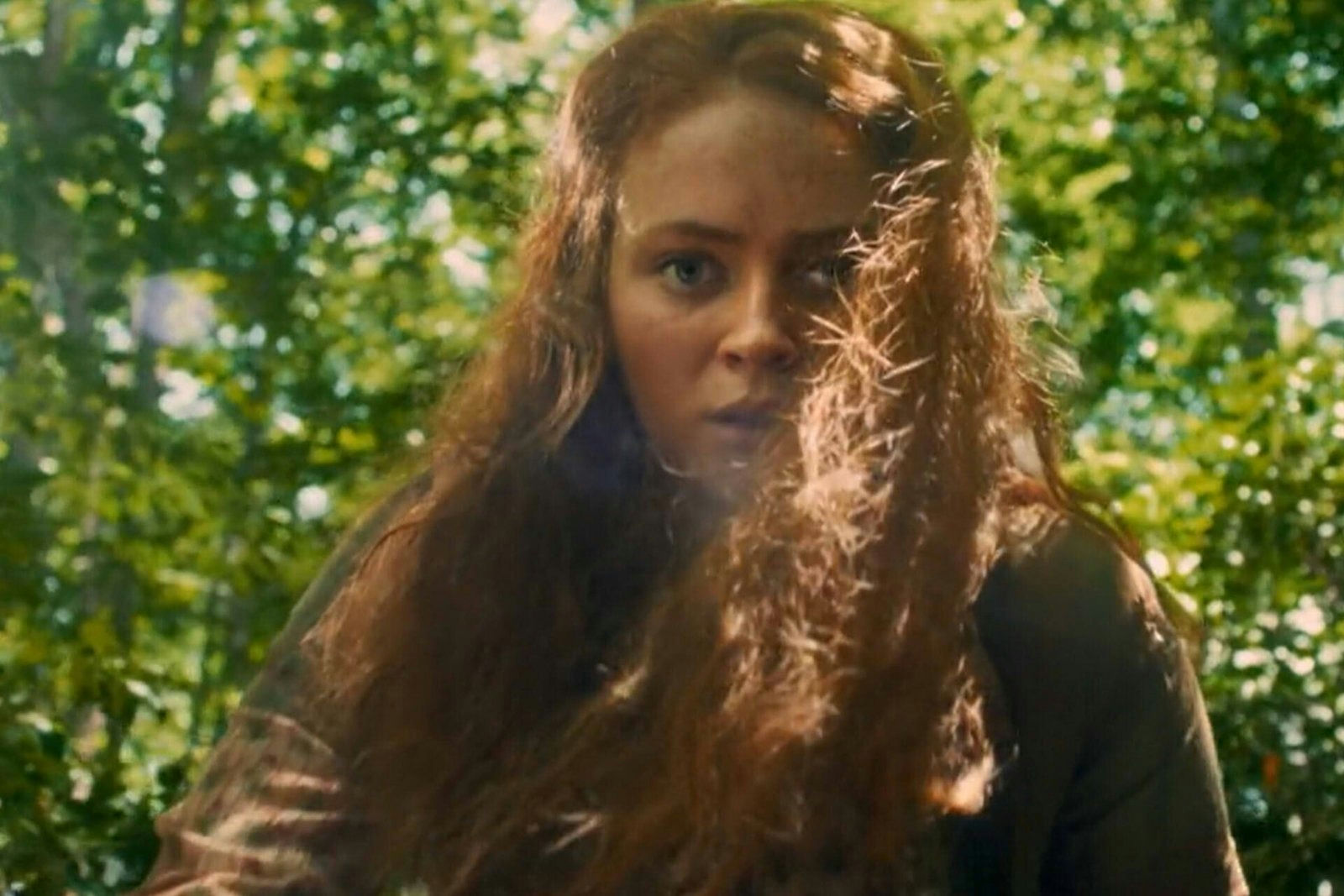 people-Young woman-A-long red hair-A-wooded area-B-intense expression-C-sunlight flare
