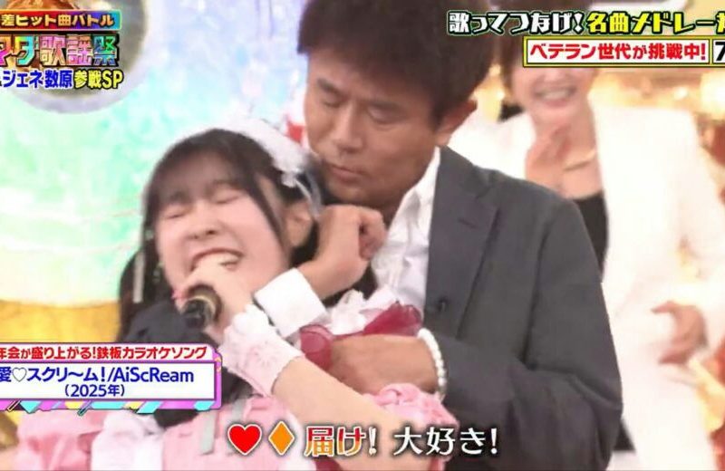 people-woman singing enthusiastically-man hugging woman from behind-woman in white smiling-A-maid outfit-A-suit-A-joyful/intense expression-B-affectionate/supportive gesture-C-background audience/performer