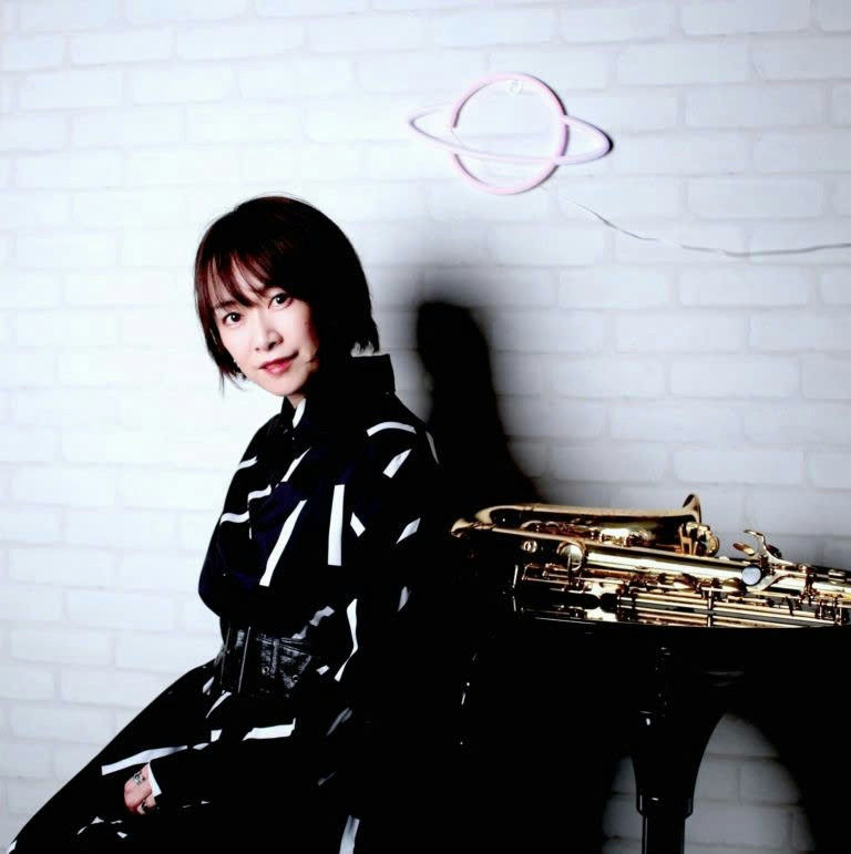 people-A-female musician-A-saxophone-A-black and white outfit-A-neon planet light