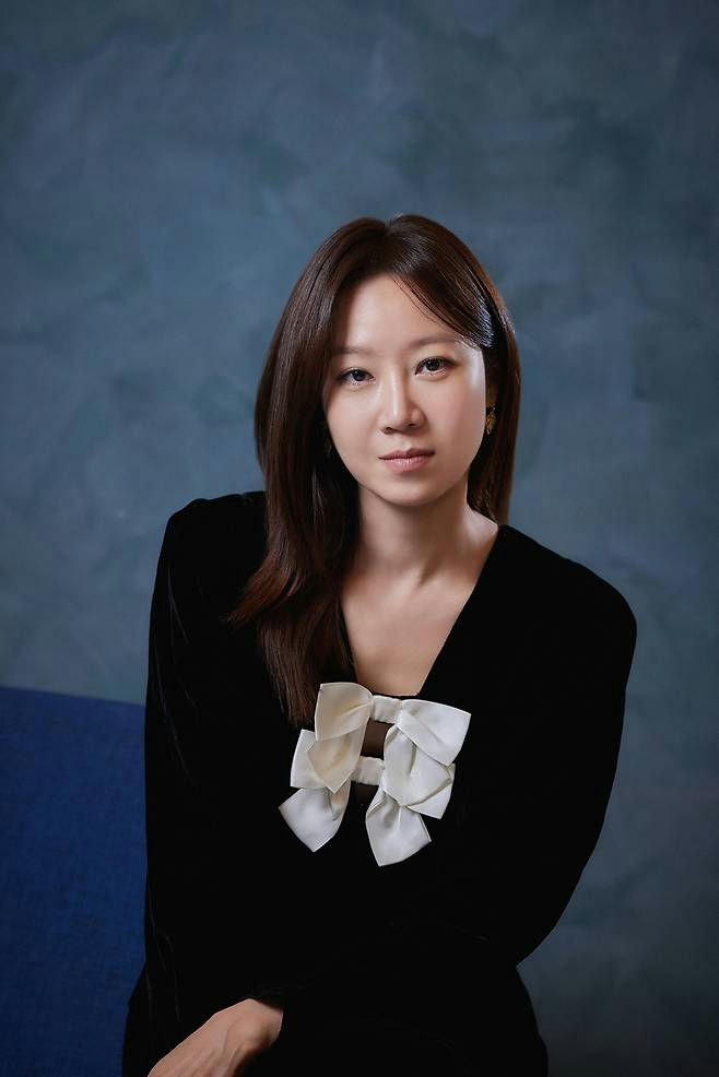 people-woman-black dress-white bow-brown hair-blue background