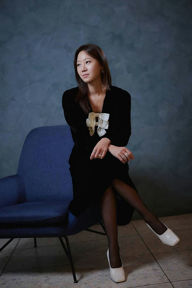 people-1-woman-A-sitting-A-black-dress-A-white-bow-A-blue-chair-A-black-stockings-A-white-square-toe-heels-A-studio-portrait