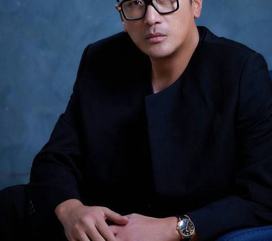 people-Man-Black clothing-Black square glasses-Dark blue background-Hands clasped-Wristwatch