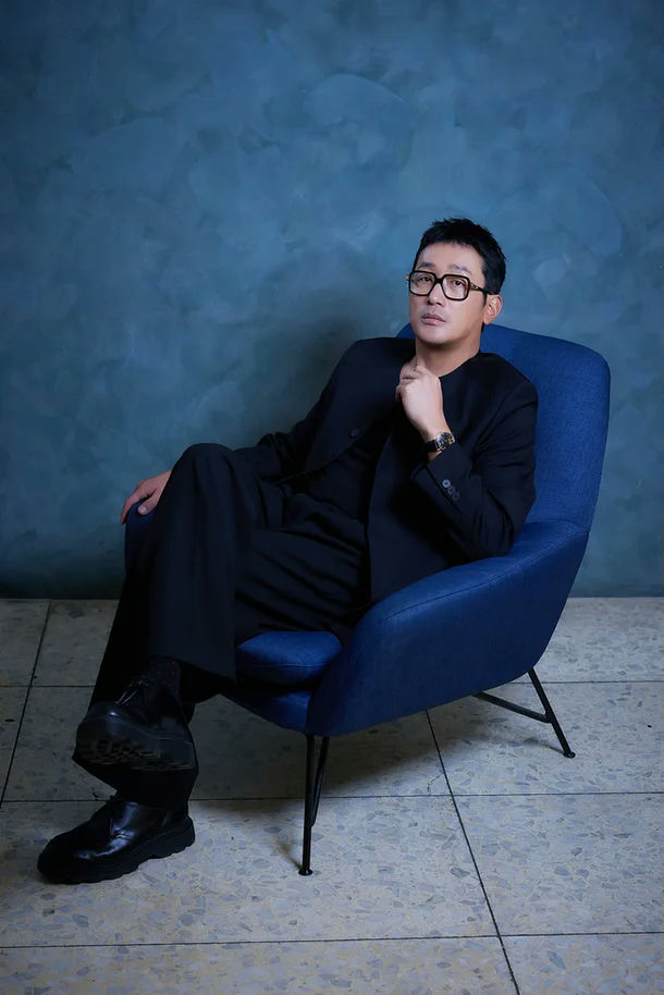 people-Man-A-Black suit-A-Blue armchair-A-Glasses-B-Sitting-B-Studio portrait-C