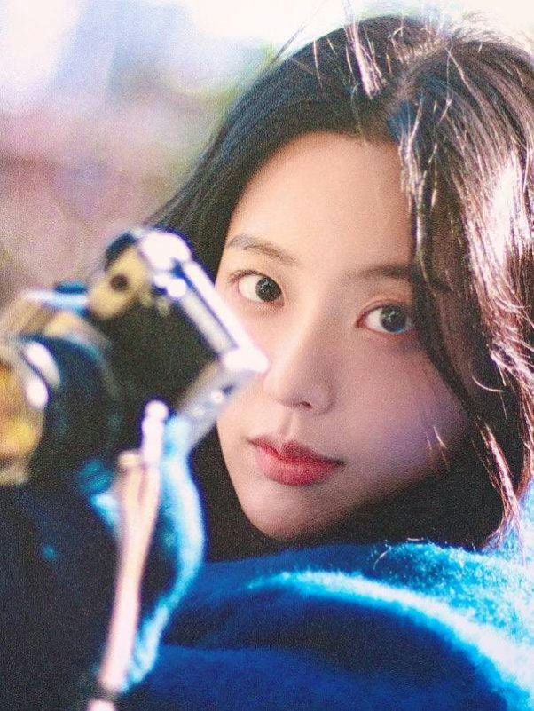 people-woman-A-dark hair-A-blue sweater-A-camera lens in foreground