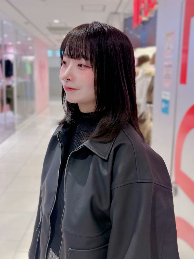 people-young woman-A-black hair-A-straight bangs-A-black faux leather jacket-A-indoor shopping area