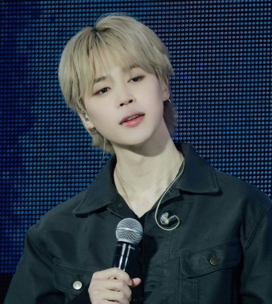 people-Jimin of BTS-A-blonde hair-A-microphone-A-dark jacket-A-blue background