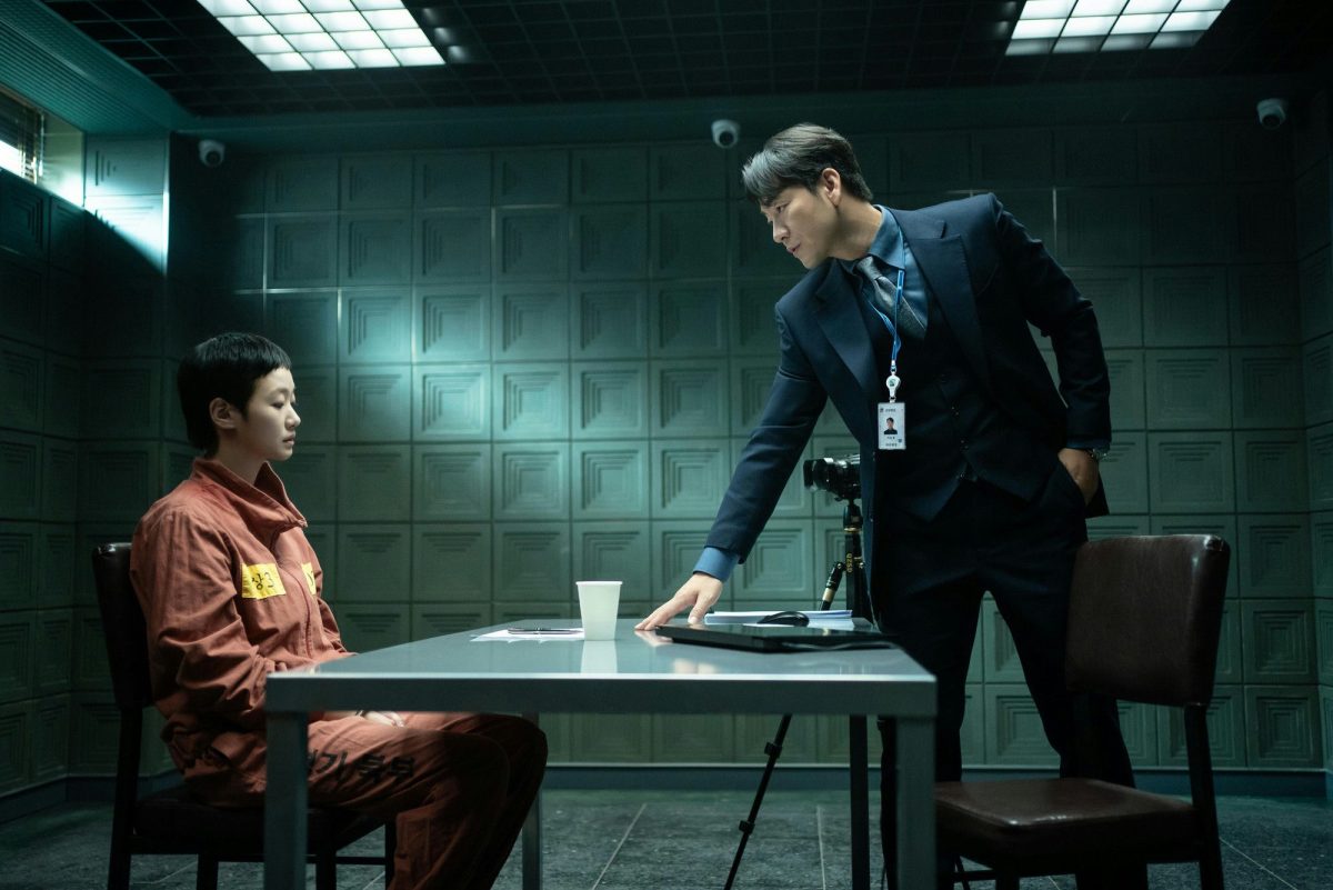 people-woman in orange jumpsuit-A-man in suit-A-interrogation room-B-surveillance cameras-C