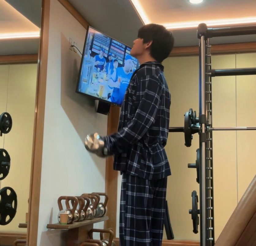 people-A-man-A-pajamas-A-gym-A-watching-TV-A-lifting-weights
