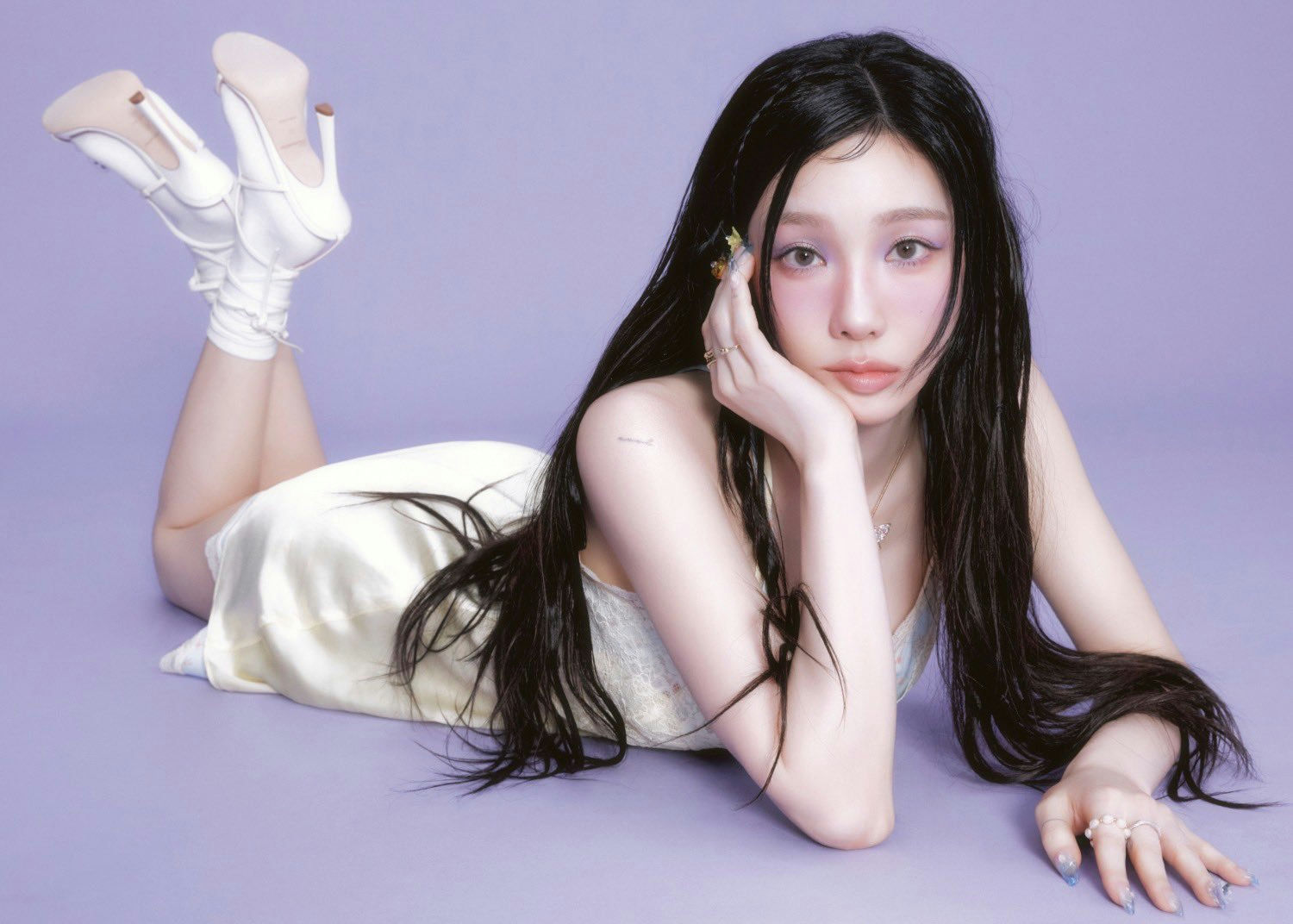 people-1-woman-A-lying down-A-long black hair-A-lavender background-A-white dress-A-high heels