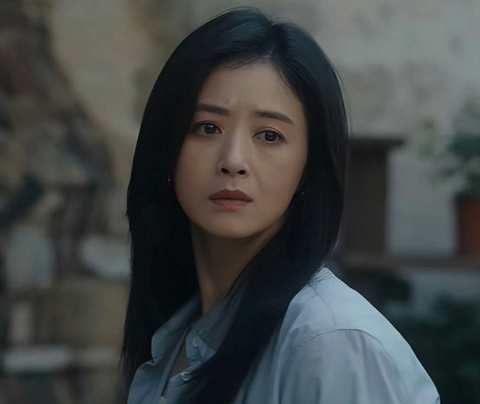 people-A-woman-A-dark hair-A-serious expression-A-light blue shirt