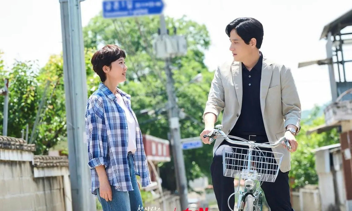 people-Two people-A-Outdoor setting-A-Man and woman talking-B-Man on a bicycle-B-Casual summer clothing-C-Korean drama promotional still