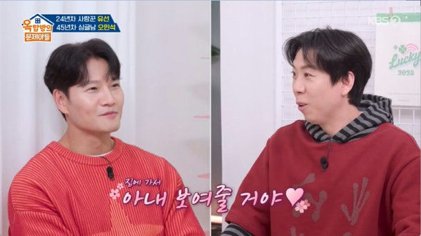people-Man on left (Kim Jong Kook)-Smiling-Man on right (Oh Min Suk)-Talking-Korean text overlay (showing part of a sentence)-Red clothing